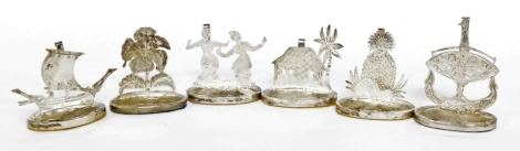 A set of six Eastern inspired name place holders, in silver coloured metal, stamped with a crown and the figure 16, to include two ships, pineapple, building, flower and two figures dancing, 4cm high.