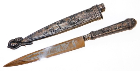 An Inox hunting knife, in a silver plated scabbard, heavily embossed with cattle scenes, of cows, bulls and sheep, with a similar designed blade, 28.5cm long.