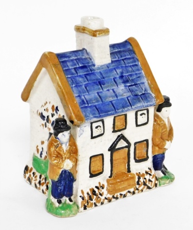 A Yorkshire type cottage, with two figures, painted in blue and brown, 14cm high.