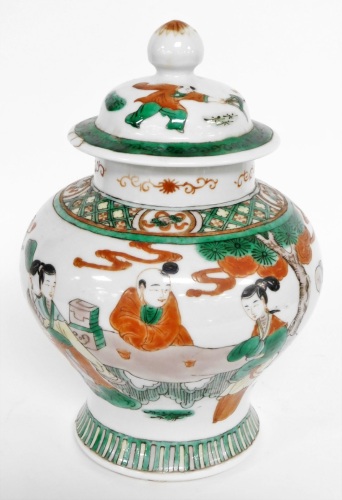 A Chinese ginger jar and cover, heavily decorated with green and red borders, and figures under trees, with character stamp to underside, 23cm high.