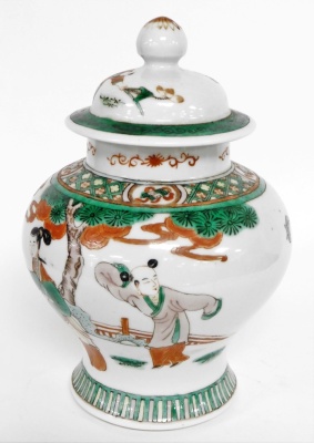 A Chinese ginger jar and cover, heavily decorated with green and red borders, and figures under trees, with character stamp to underside, 23cm high. - 2