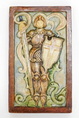 A Compton pottery plaque of a warrior, on a brown border, with stamp to rear, 18cm x 11cm.