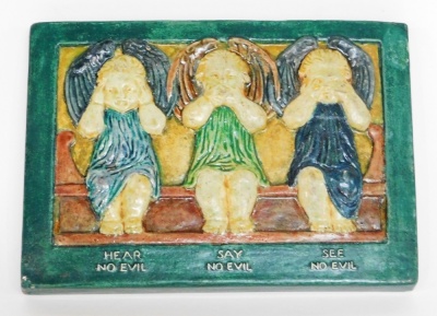 A Compton pottery plaque of three cherubs, hear no evil, say no evil, see no evil, with Compton pottery stamp to reverse, 15cm x 11cm.