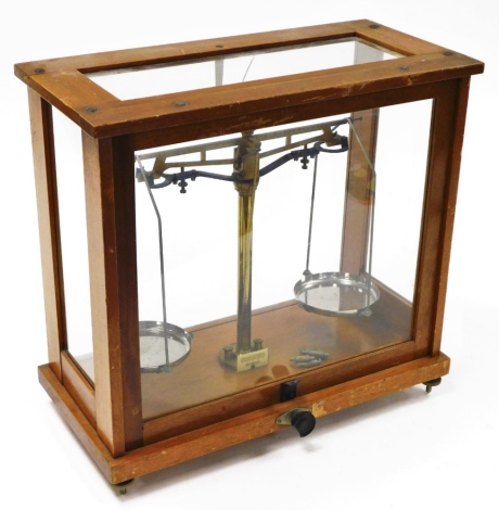 An oak and brass chemists scale, with two tier balance and brass centrepiece on screw wooden handles, 39cm high, 40cm wide, 20cm deep.