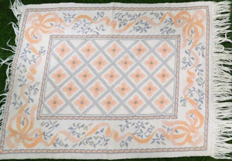 A wool cut rug, with central rectangular panel on a cream ground with peach flowers, on tassel ends, 116cm x 88cm.