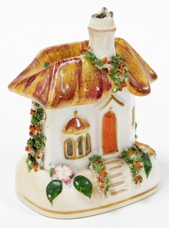 A Staffordshire style cottage, with thatched roof and painted floral panelling, 12cm high. (AF)