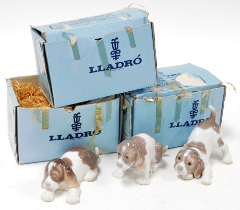 Three Lladro porcelain figures of spaniel puppies, in varying poses, comprising two 15cm wide and one 7cm high., each boxed. (3)