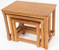 A Robert Thompson of Kilburn 'Mouseman' nest of three oak tables, bearing carved mouse to a leg of each table, the largest 47cm high, 59cm wide, 38cm deep.