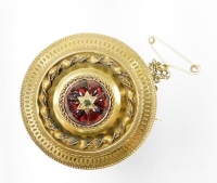 A Victorian memorial brooch, with central six triangular cut rubies, and a diamond with twist design border on memorial panel back with safety pin, yellow metal, unmarked, 3.5cm wide.