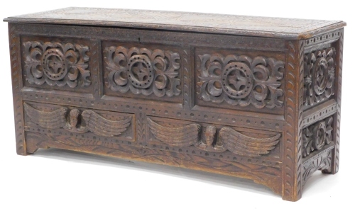 A late 19thC stained oak mule chest, the hinged top carved with lozenges and with a moulded border, above a frieze with applied carvings and two drawers each decorated with winged figures, on stiles, 54cm high, 120cm wide, 41cm deep. Provenance: Purchase