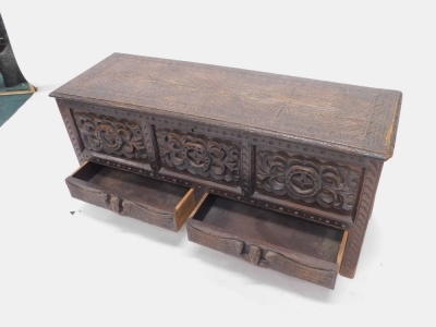 A late 19thC stained oak mule chest, the hinged top carved with lozenges and with a moulded border, above a frieze with applied carvings and two drawers each decorated with winged figures, on stiles, 54cm high, 120cm wide, 41cm deep. Provenance: Purchase - 2