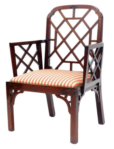 A George III mahogany Cockpen chair, with a shaped back and arms each with a lattice insert, with a drop in seat on chamfered legs, each with brackets, 68cm wide.