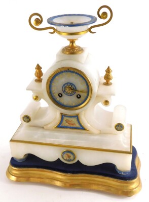 A late 19thC continental alabaster mantel clock, with an urn shaped two handled crest, the dial with blue lapis coloured border, above part painted panels decorated with a female mask and a putto, on a gilt plinth, 37cm high overall 30cm wide.