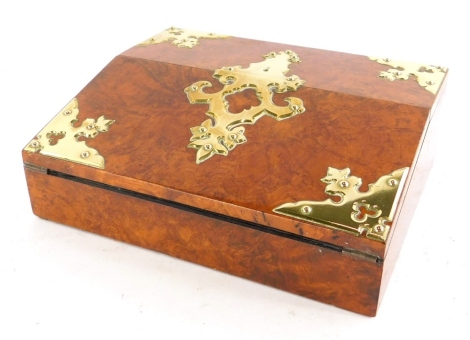 A Victorian figured walnut and brass writing slope, the hinged lid enclosing a velvet lined interior and a vacant inkwell compartment, 30cm wide.