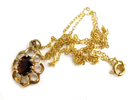 A 9ct gold pendant and chain, the floral pendant set with garnet in claw setting, on a fine link yellow metal chain, marked 9kt, 1.7g all in.