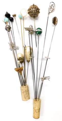 A group of hat pins, to include an enamelled top hat pin, a silver framed metallic circular hat pin, faux pearl set hat pins, etc.