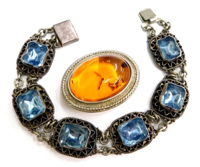 A group of silver and other jewellery, to include a blue paste stone set bracelet, in a white metal frame, unmarked, with filigree detailing, 20cm long, and an imitation amber bar brooch in silver plated frame, 4cm wide. (2)