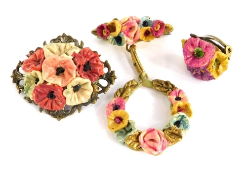 A small group of floral jewellery, with applied clay flower detailing, comprising two brooches and a clip on earring.