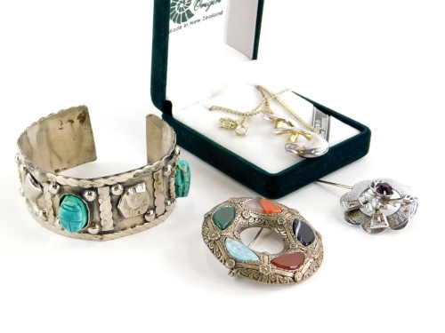 A group of silver and other jewellery, comprising a modern pewter Pacific Ocean pendant and chain, boxed, a white metal Eastern bangle, unmarked, and two silver plated Scottish style brooches, each stone set. (4)