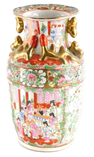 A Chinese porcelain Canton style vase, decorated with gilt handles, lizard figures, etc., an overall enamel decoration of figures within buildings, bird and flowers, red printed marks to underside and label Made In Macau, 36cm high.