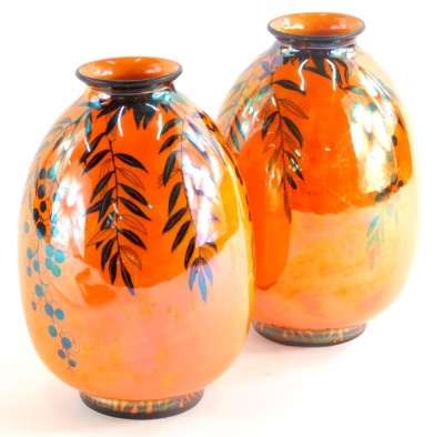 A pair of Crown Ducal lustre vases, each decorated with flowers and leaves in black on a vivid orange lustre ground, printed marks to underside, 20cm high.