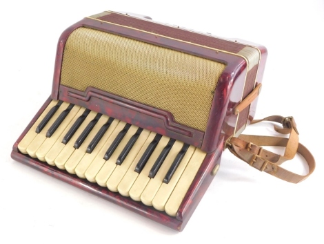 A small piano accordion, in red marbled case, possibly Italian, 32cm wide.