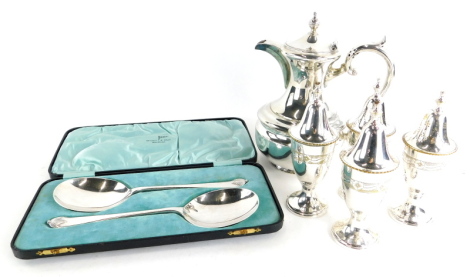 A collection of silver plated wares, to include a set of four urn shaped salt and pepper pots, hot water jug, and a cased set of serving spoons.