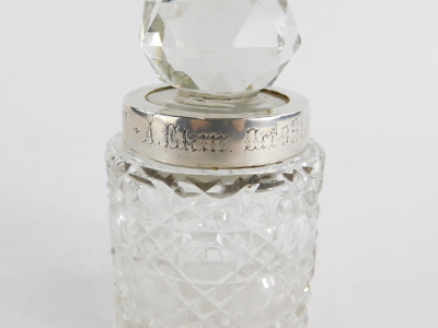 Two cut glass dressing table jars, one with a cut glass stopper and silver collar, engraved with the inscription A. Ekin Oct 9th 1900, Birmingham 1899, 11cm high, the other with a silver topped screw top lid, Birmingham 1938, 12cm high. (2) - 2