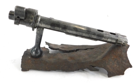 A World War One Mauser K98 bolt, mounted onto a piece of shrapnel.