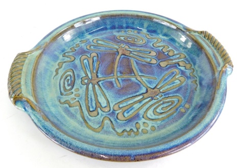 A Will Illsley studio pottery two handled dish, with purple and turquoise high fired lustre glazes, depicting dragonflies, makers impressed mark to underside, 34cm wide.