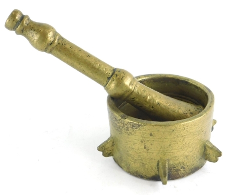 A brass pestle and mortar, the circular mortar of drum form, the pestle with turned decoration, possibly 18thC.