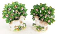 A pair of late 19th/early 20thC porcelain bocage figures, each modelled with a sheep, gold anchor mark to reverse, possibly Samson, 15cm high.