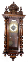 A Vienna wall clock, in a walnut case with part enamel and brass dial, flanked by a pair of pilasters, also including two associated crests, 92cm high. (AF)