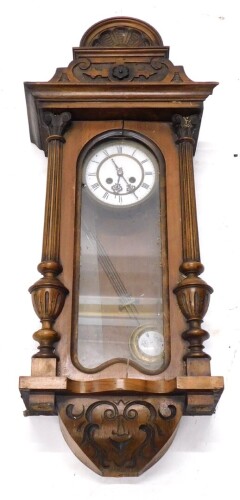 A late 19th/early 20thC Vienna wall clock, in a walnut case with white enamel dial, flanked by two part reeded pilasters, 83cm high. (AF)