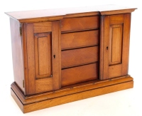 A Victorian mahogany small cabinet, modelled in the form of a wardrobe or clothes press, with two panel doors, enclosing four drawers on a plinth, 43cm wide.