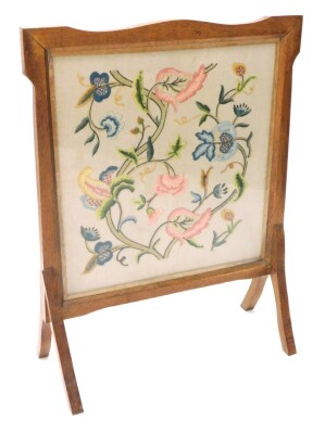 An early 20thC Arts and Crafts oak firescreen, with crewel work banner, 65cm wide.