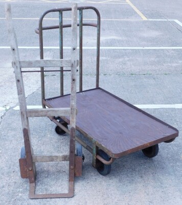 An Industrial grill painted tubular iron trolley, with hardwood top, 30cm x 61cm, and a pair of oak and iron sack trucks. (2)