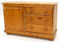 A late 19th/early 20thC stripped pine Lincolnshire type dresser, the planked top with a moulded edge, above an arrangement of three drawers and a panelled door, on bun feet, 120cm wide.