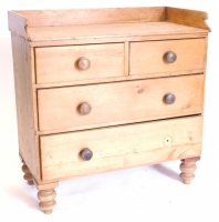 A Victorian pine wash stand, with a raised back above two short and two long drawers on turned feet.