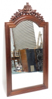 A mahogany wall mirror, with a leaf carved pierced crest, above a reeded arched frame, 147cm high, 77cm wide.