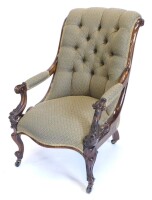 A Victorian rosewood armchair, with scroll carved showframe, buttoned padded back, arm rests and seat, on cabriole legs with castors.