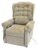 An electric rise and fall armchair, upholstered in patterned grey fabric.