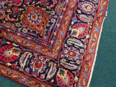 A large Persian Meshed type carpet, with a central medallion, surrounded by an elaborate design to the floral red ground, with blue spandrels, one wide and three narrow borders, 373cm x 280cm. - 2