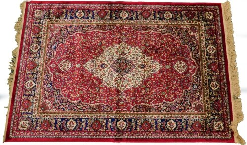 A red ground Kashmere type rug, with a design of a cream medallion, on a red ground with blue spandrels and one wide and two narrow borders, 170cm x 120cm.