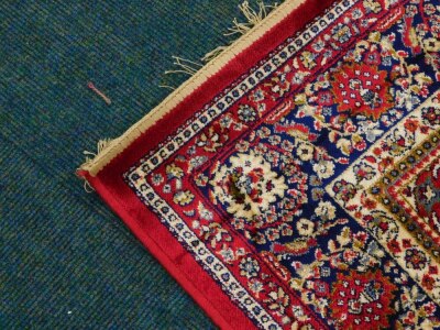 A red ground Kashmere type rug, with a design of a cream medallion, on a red ground with blue spandrels and one wide and two narrow borders, 170cm x 120cm. - 2