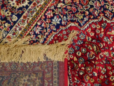 A red ground Kashmere type rug, with a design of a cream medallion, on a red ground with blue spandrels and one wide and two narrow borders, 170cm x 120cm. - 3