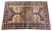 An Afghan Kazak type rug, with a central lozenge, with lozenge and geometric motifs, on a beige ground with one wide and two narrow borders, 120cm x 84cm.