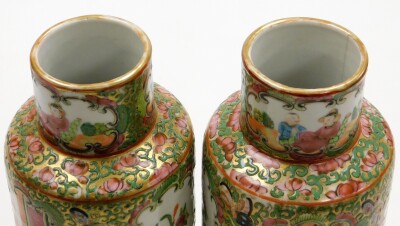 A pair of Chinese Canton vases, each with panels of figures, birds and flowers on a gilt and green flowered ground, 19thC, 26cm high. - 26