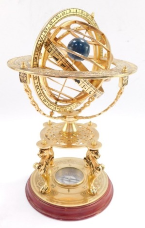 A brass orrery, with an astrological plate, raised on four supports above a table type base on three lion's paws supports, above a circular base inset with a compass, 26cm high. (AF)