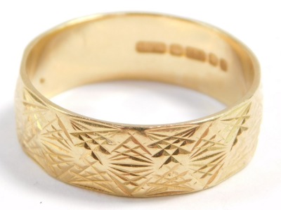 An 18ct gold wedding band, with engraved and faceted decoration, size R, 4.9g.